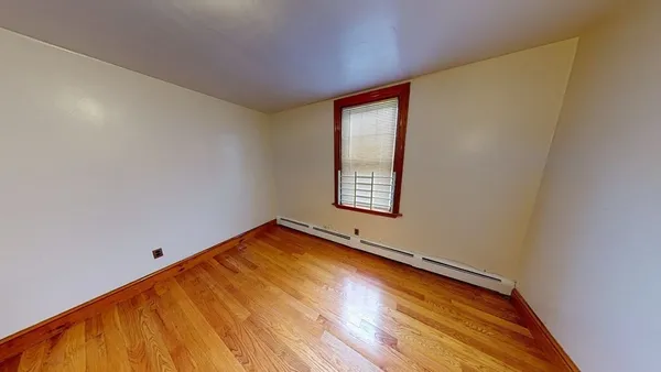a view of a room with wooden floor and a window