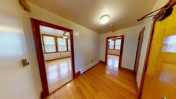 a view of a hallway with wooden floor and stairs