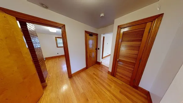 a view of a hallway with wooden floor and stairs