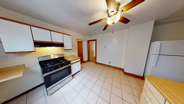 a kitchen with stainless steel appliances a stove a refrigerator cabinets and a dining table