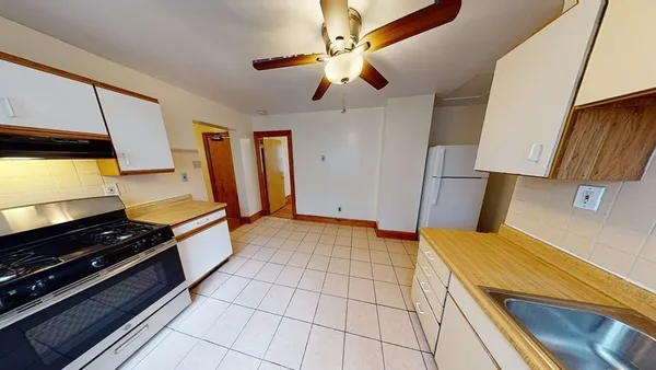 a kitchen with stainless steel appliances a stove a refrigerator cabinets and furniture