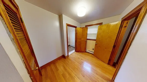 a view of a hallway with wooden floor and stairs