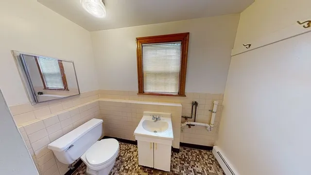 a bathroom with a toilet a sink and a mirror