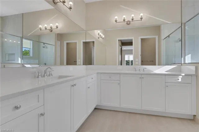 a bathroom with double vanity and a mirror