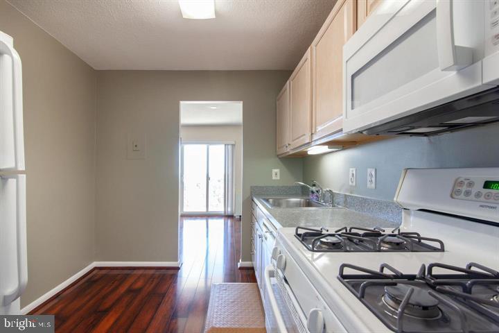 1121 University Boulevard West Silver Spring, MD 20902 - Photo 11 of 20 a kitchen with a stove and wooden floor