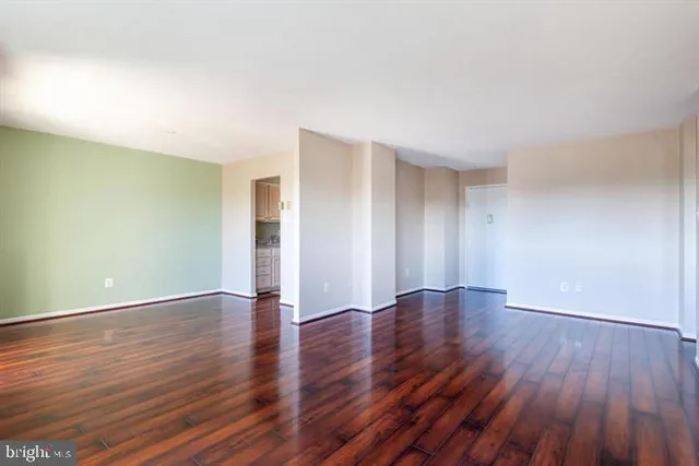 a view of an empty room with wooden and a window