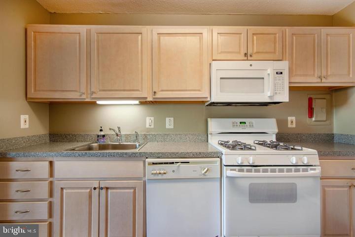 1121 University Boulevard West Silver Spring, MD 20902 - Photo 9 of 20 a kitchen with granite countertop white cabinets and white appliances