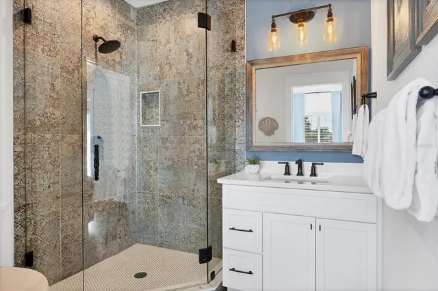 a bathroom with a granite countertop sink toilet and shower