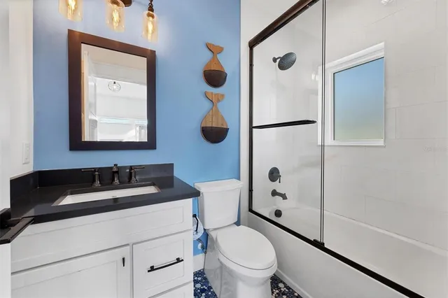 a view of a house with a large window and wooden fence