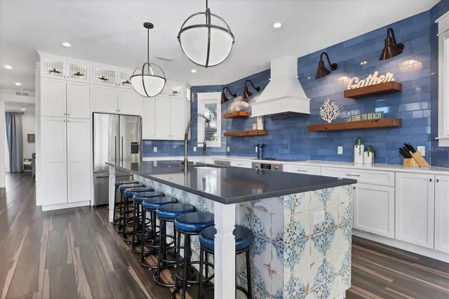 a kitchen with stainless steel appliances granite countertop a sink a stove and a wooden floors