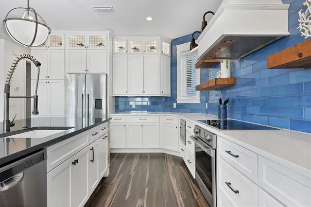 a kitchen with stainless steel appliances granite countertop a sink and cabinets