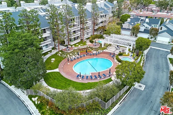 a view of a swimming pool with a patio and plants