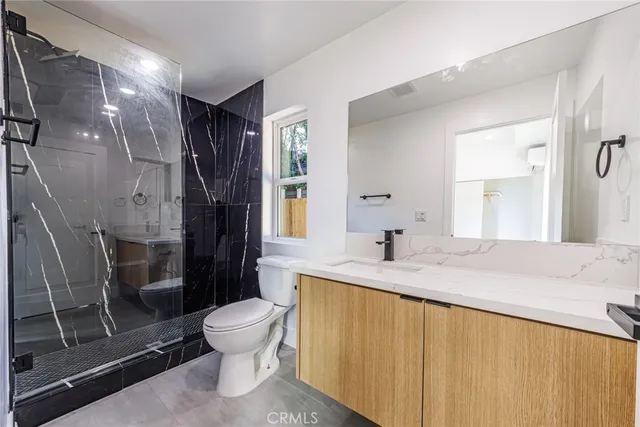 a bathroom with a granite countertop sink toilet and shower