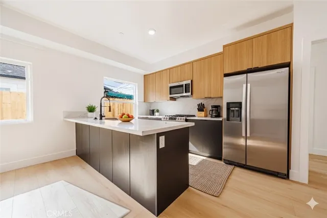 a kitchen with stainless steel appliances a refrigerator and a stove top oven