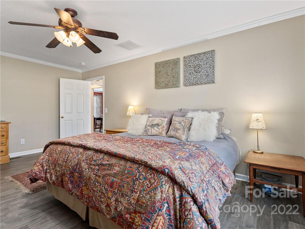 1085 Hooper Creek Road Tryon, NC 28782 - Photo 17 of 34 a bedroom with bed and a chandelier
