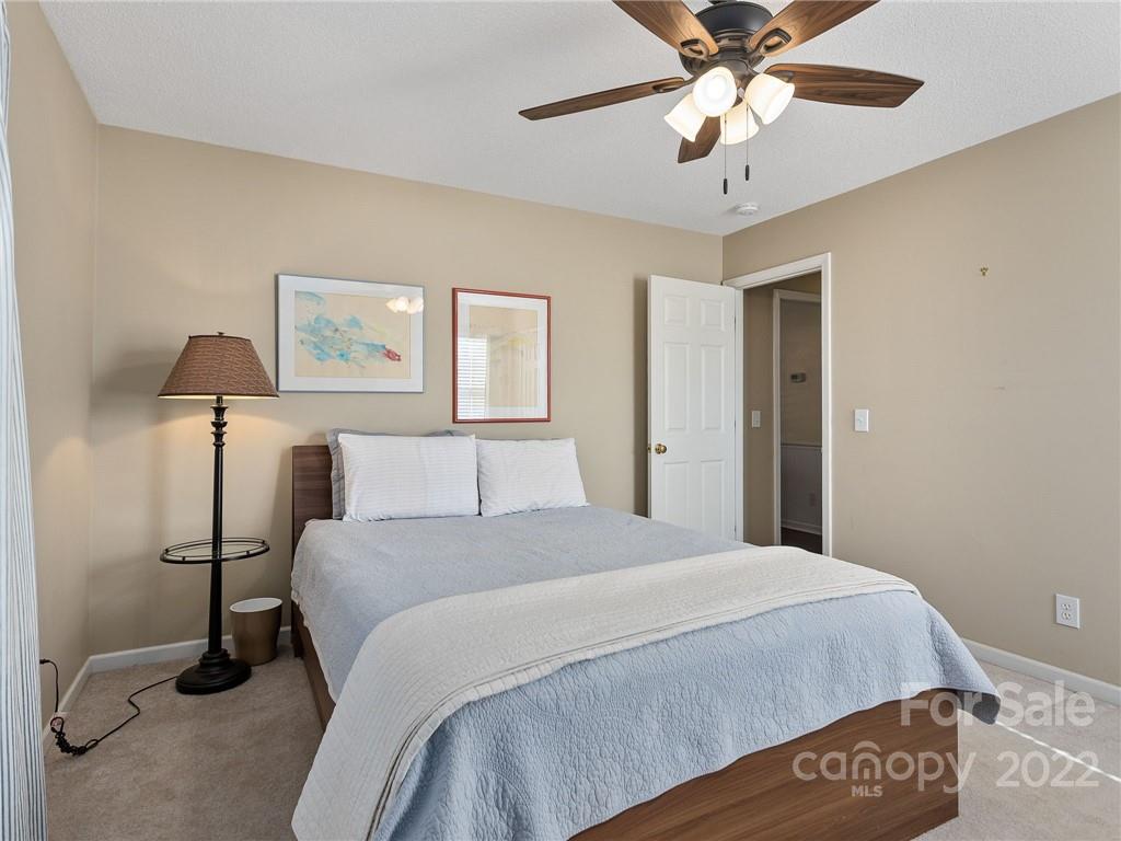 1085 Hooper Creek Road Tryon, NC 28782 - Photo 23 of 34 a bedroom with a bed and a chandelier