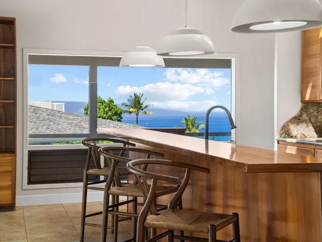 a kitchen with stainless steel appliances a table and chairs in it