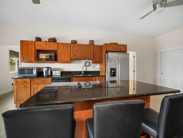 a kitchen with stainless steel appliances granite countertop a refrigerator and a stove top oven