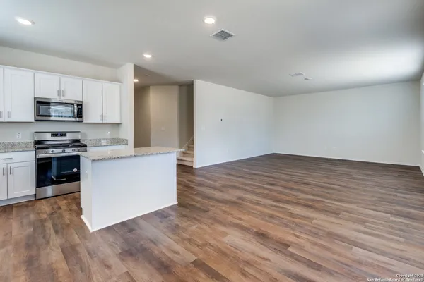 a kitchen with stainless steel appliances granite countertop a stove a sink and a refrigerator