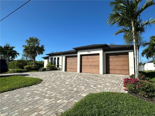 a front view of a house with a garden and yard