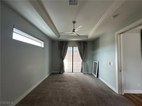 an empty room with a windows and ceiling fan