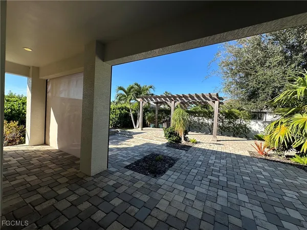 a view of a porch with a floor to ceiling window and potted plants