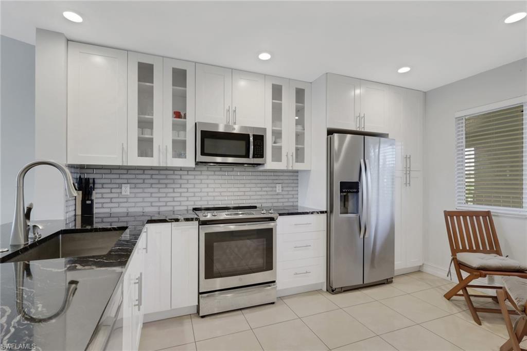 7766 Emerald Circle, Unit R203 Naples, FL 34109 - Photo 6 of 25 a kitchen with a refrigerator sink and stove