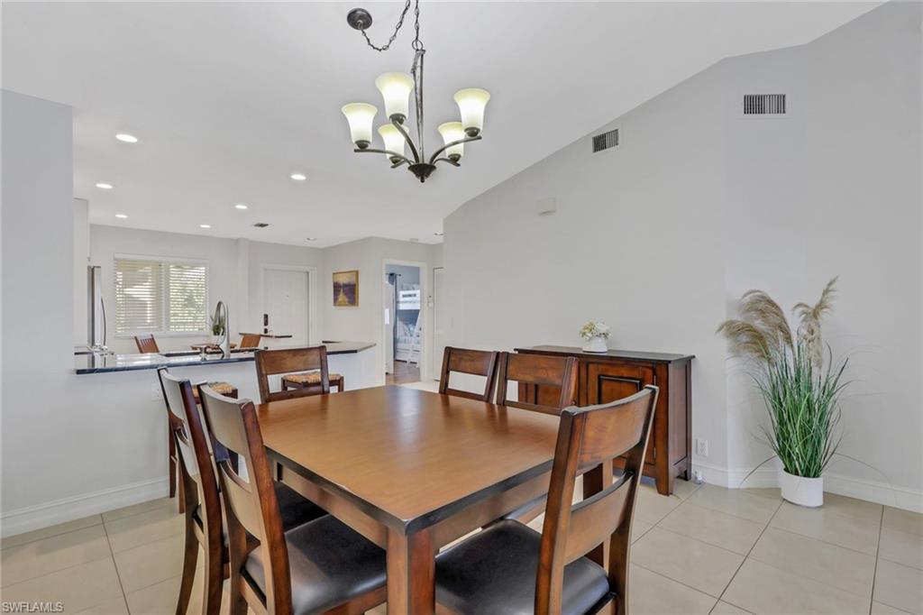 7766 Emerald Circle, Unit R203 Naples, FL 34109 - Photo 10 of 25 a view of a dining room with furniture and wooden floor
