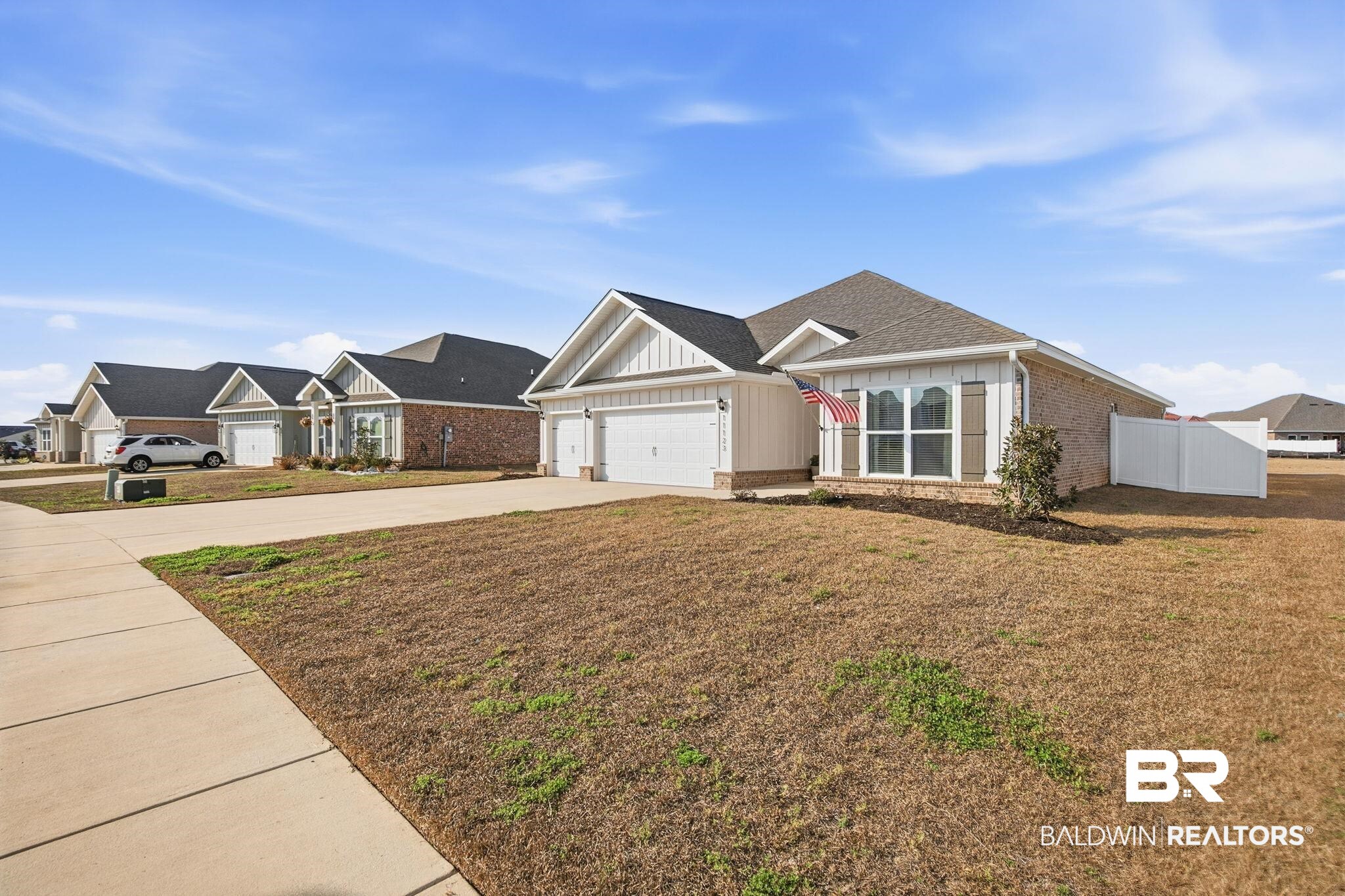 11123 Genuine Risk Circle Daphne, AL 36526 - Photo 6 of 67 View of front of house with board and batten siding, driveway, brick siding, a garage, and a residential view