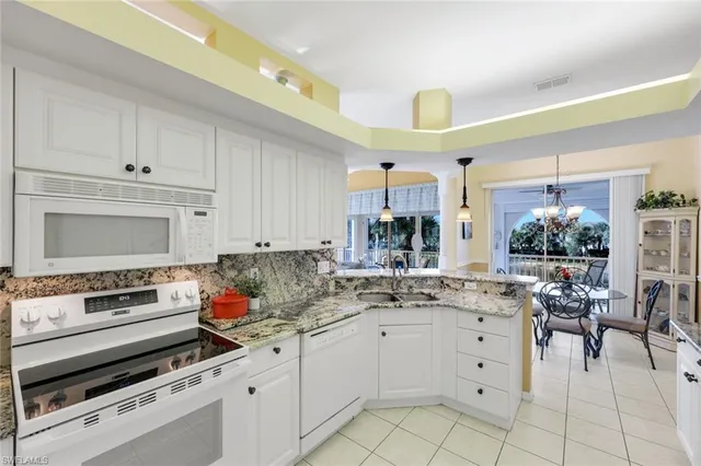 a kitchen with white cabinets and appliances