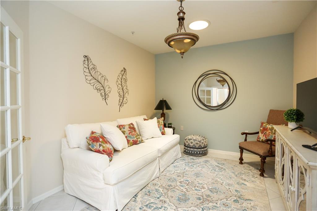 8175 Celeste Drive, Unit 1230 Naples, FL 34113 - Photo 13 of 35 a living room with furniture a clock and a window