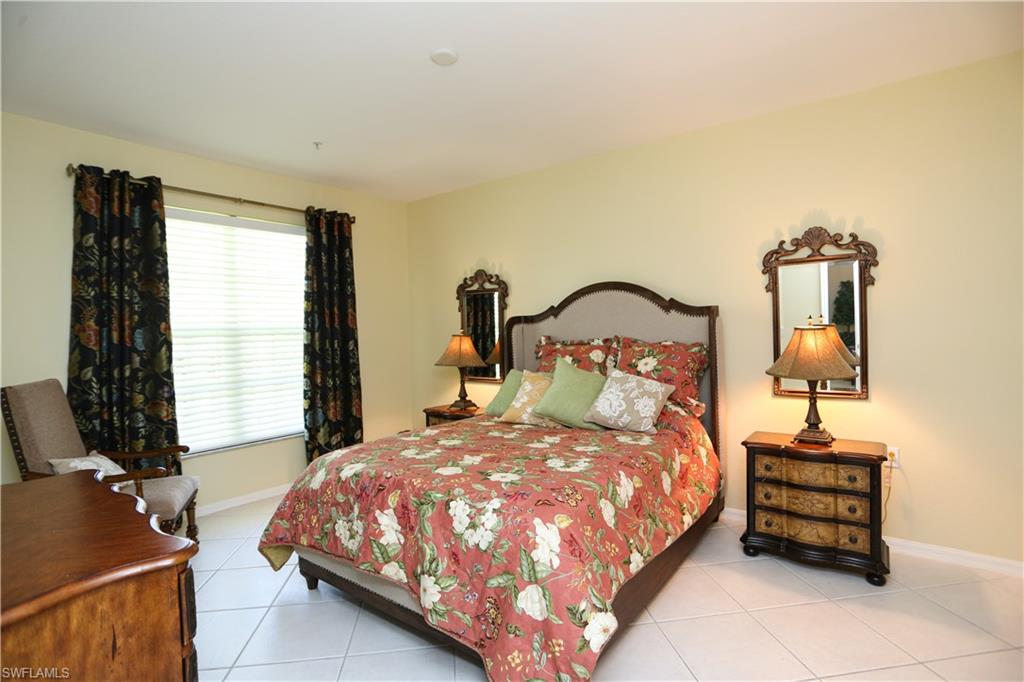 8175 Celeste Drive, Unit 1230 Naples, FL 34113 - Photo 15 of 35 a bedroom with a bed and a flat tv screen on a dresser