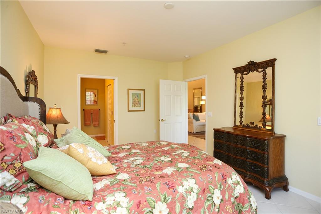 8175 Celeste Drive, Unit 1230 Naples, FL 34113 - Photo 17 of 35 a bedroom with a bed and dresser with mirror