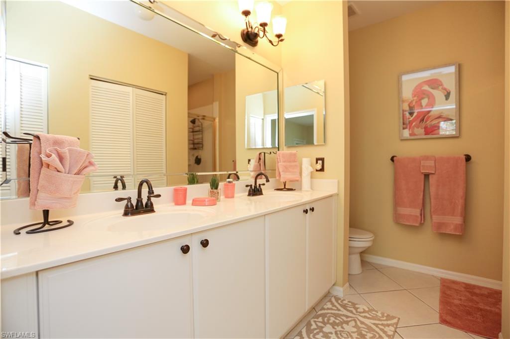 8175 Celeste Drive, Unit 1230 Naples, FL 34113 - Photo 19 of 35 a bathroom with a double vanity sink mirror and toilet