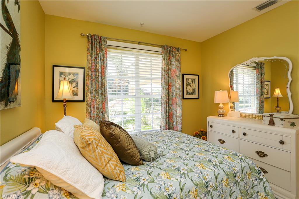 8175 Celeste Drive, Unit 1230 Naples, FL 34113 - Photo 22 of 35 a bedroom with a bed mirror on dresser and a window