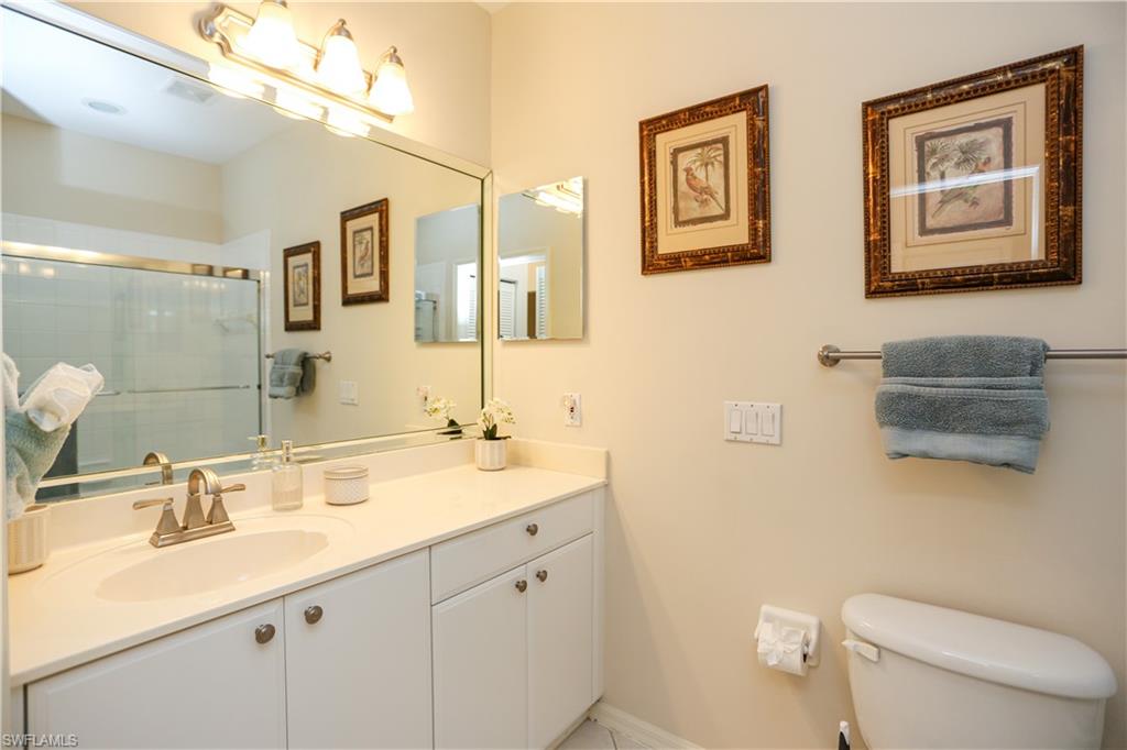 8175 Celeste Drive, Unit 1230 Naples, FL 34113 - Photo 24 of 35 a bathroom with a toilet sink and mirror