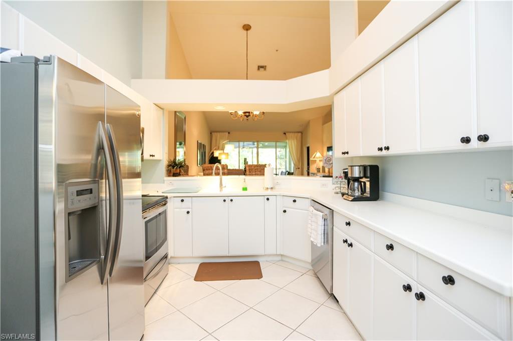 8175 Celeste Drive, Unit 1230 Naples, FL 34113 - Photo 10 of 35 a kitchen with white cabinets and refrigerator