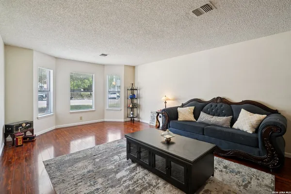 a living room with furniture and a wooden floor