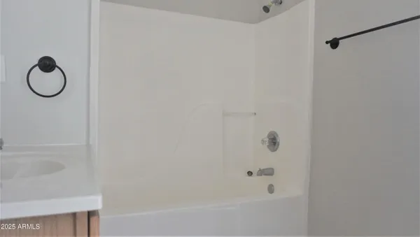 a bathroom with a granite countertop bathtub and a shower