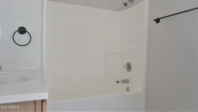 a bathroom with a granite countertop bathtub and a shower