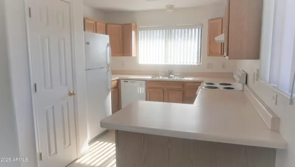 a kitchen with stainless steel appliances a refrigerator a sink a stove and white cabinets