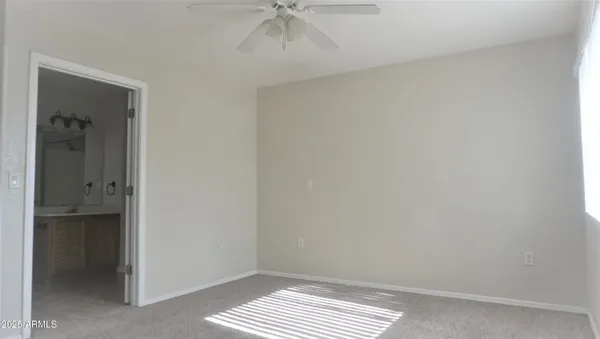 a view of an empty room and a ceiling fan