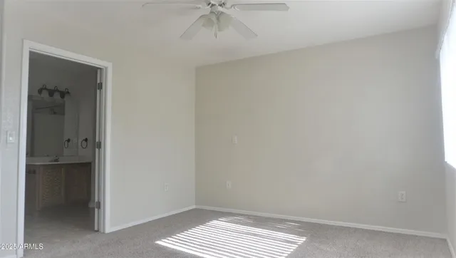 a view of an empty room and a ceiling fan