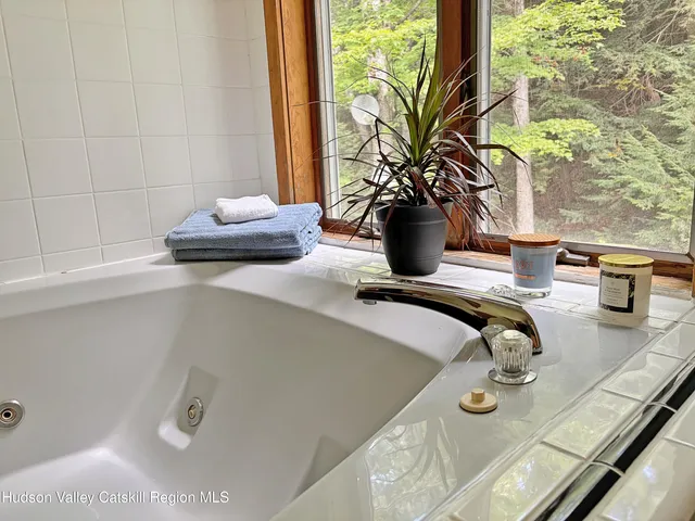 a spacious bedroom with a bed a dresser and a large window