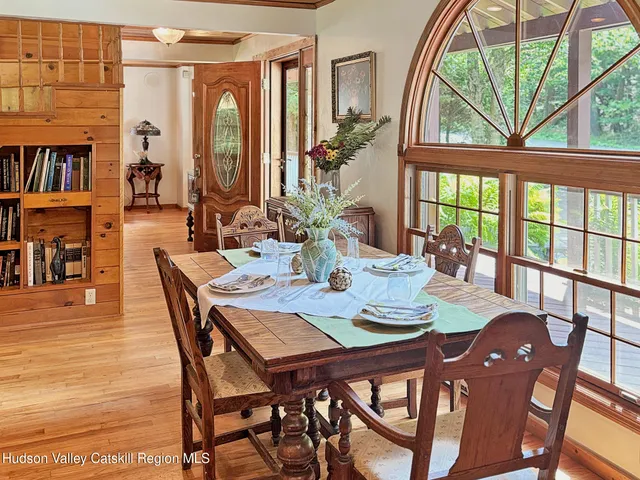 a dining room with furniture a rug a potted plant and a chandelier