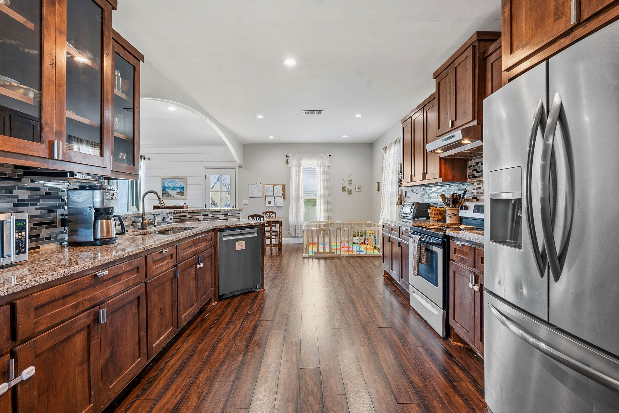 574 Highland Ranch Way Dale, TX 78616 - Photo 9 of 27 a kitchen with stainless steel appliances granite countertop a refrigerator a sink dishwasher a stove and a oven with wooden floor
