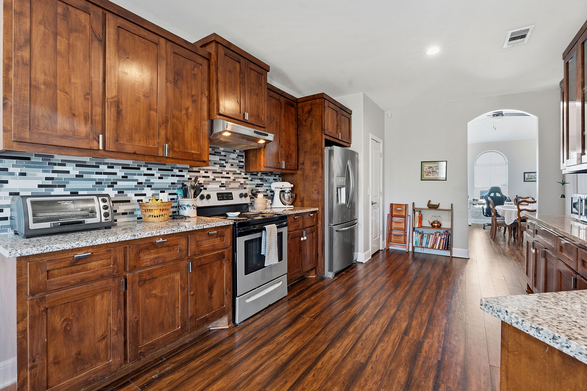 574 Highland Ranch Way Dale, TX 78616 - Photo 10 of 27 a kitchen with stainless steel appliances granite countertop a refrigerator a sink dishwasher a stove and white countertops with wooden floor