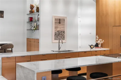 a view of a kitchen with kitchen island stainless steel appliances a table and chairs