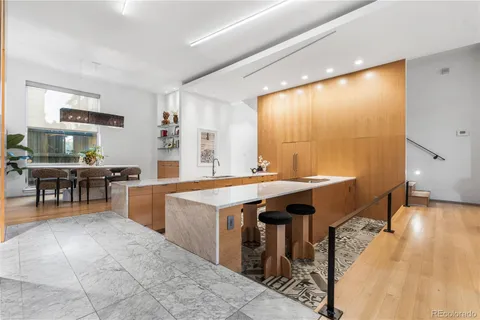 a large living room with stainless steel appliances granite countertop a sink a stove and a large mirror