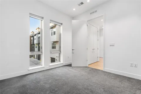 a bathroom with a granite countertop sink a toilet a mirror and shower